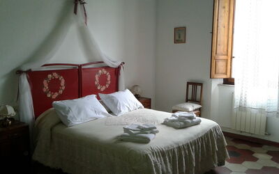 Double room with large wardrobe, a sideboard with mirror, a table with chair.
Complete with antique iron and ceramic washbasin