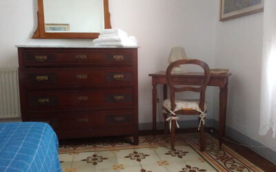 Master bedroom with vaulted ceiling and original Greek hand painted, wardrobe and sideboard in solid wood with mirror.
Equipped washbasin in iron and ceramic.
There is also a table with a chair.
Two bedside tables with light on the sides of the bed.